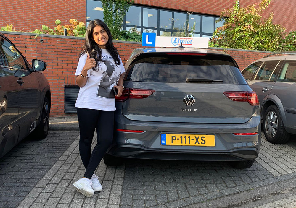 Geslaagde leerling bij de lesauto in Amsterdam